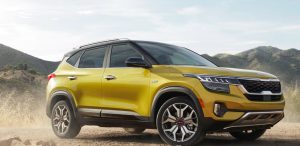 Profile view of a golden yellow 2022 Kia Seltos parked in a rocky plains open area. | Kia dealer in Sherwood, AR.