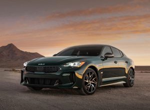A parked, black 2022 Kia Stinger with its headlights on. | Kia dealer in Sherwood, AR.