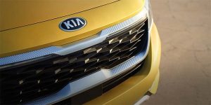 Close view of the grille area of a golden yellow 2021 Kia Seltos. | Kia dealer in Sherwood, AR.