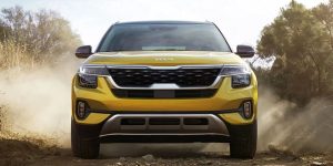Close view of the front grille area of a golden yellow 2022 Kia Seltos. | Kia dealer in Sherwood, AR.