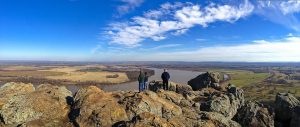 3 people on the top of a rocky mountain looking at the view down below. | Great views around Sherwood, AR.