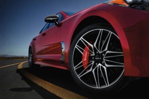 Close view of the bottom tire area of a red 2022 Kia Stinger. | Kia service in Sherwood, AR.