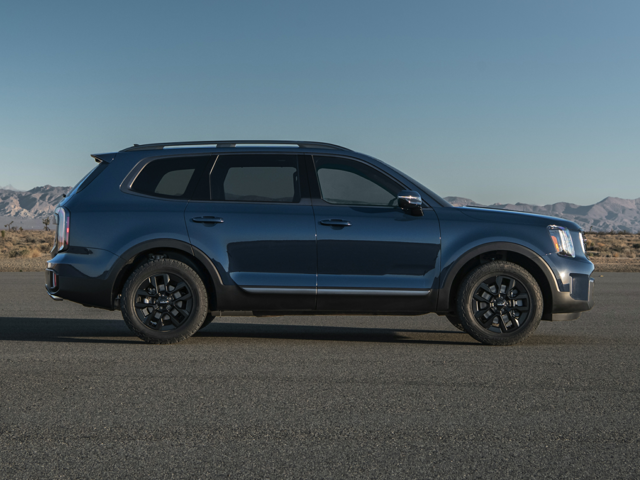 Profile view of a parked, navy blue 2023 Kia Telluride with mountains far off in the background. | Kia dealer in Sherwood, AR.